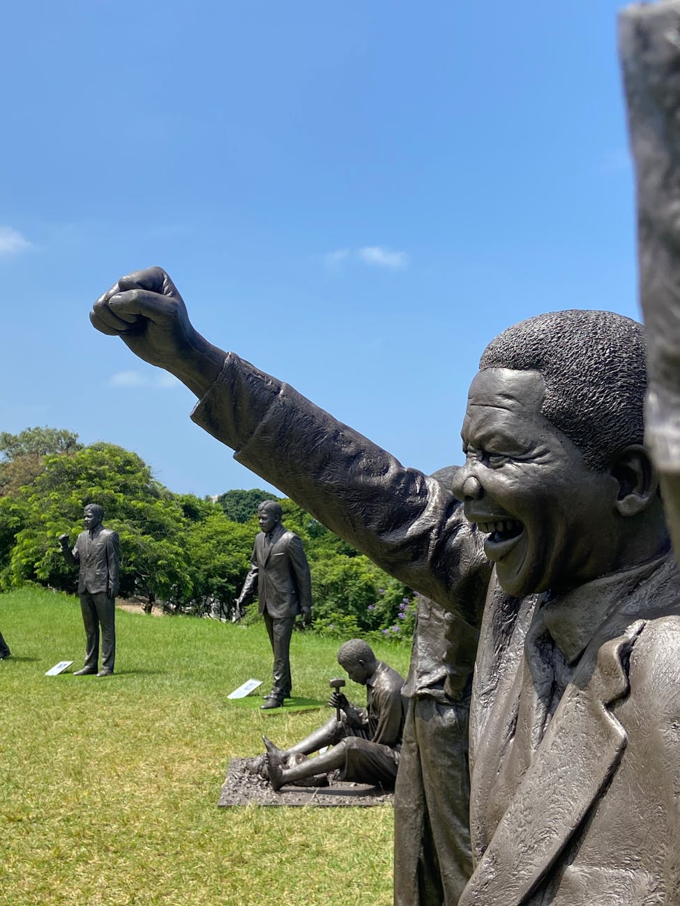 sculptures of famous people on a field outdoors