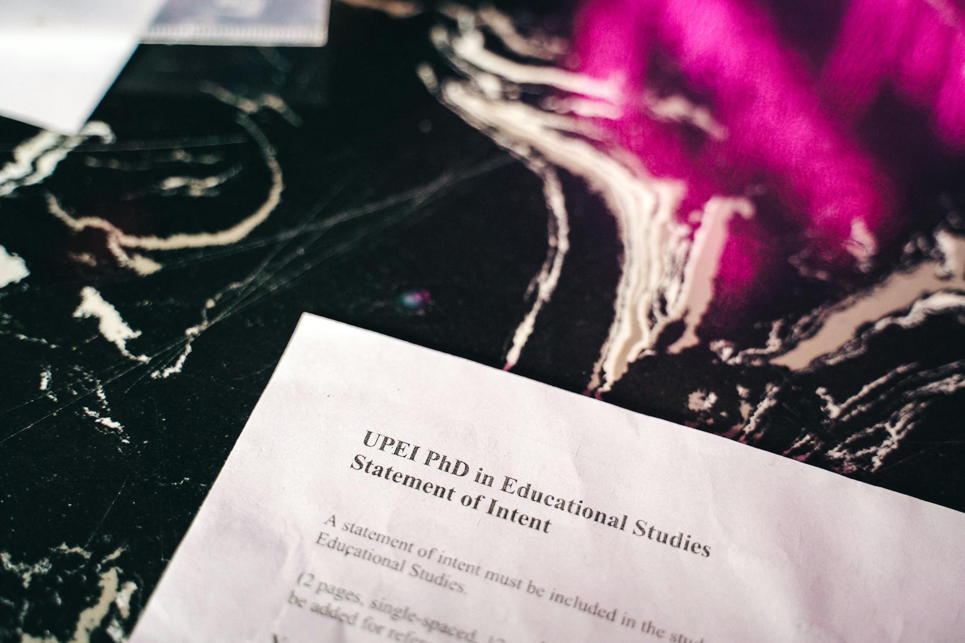close up shot of a document on a black marbled surface