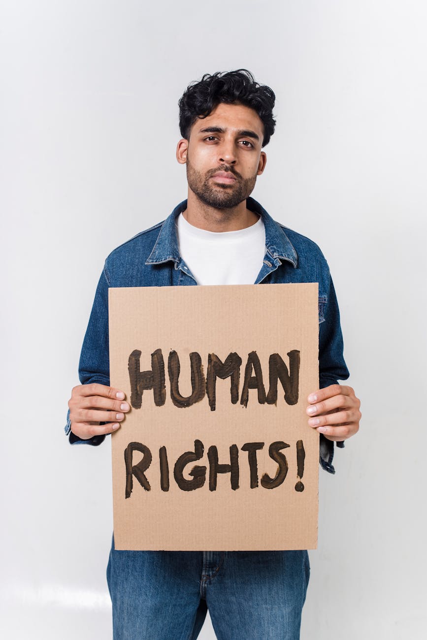 man in blue and white long sleeve shirt holding human rights text