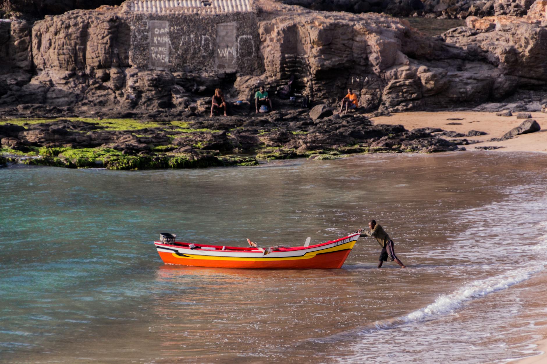 man pushing boat in sea