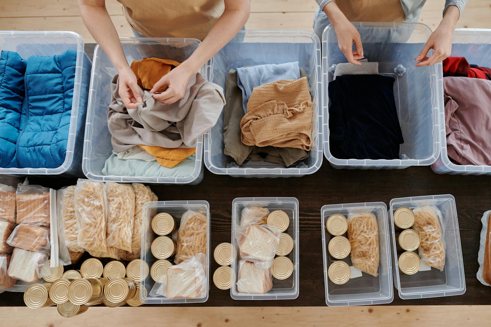 clothing in plastic containers and food in cans on table