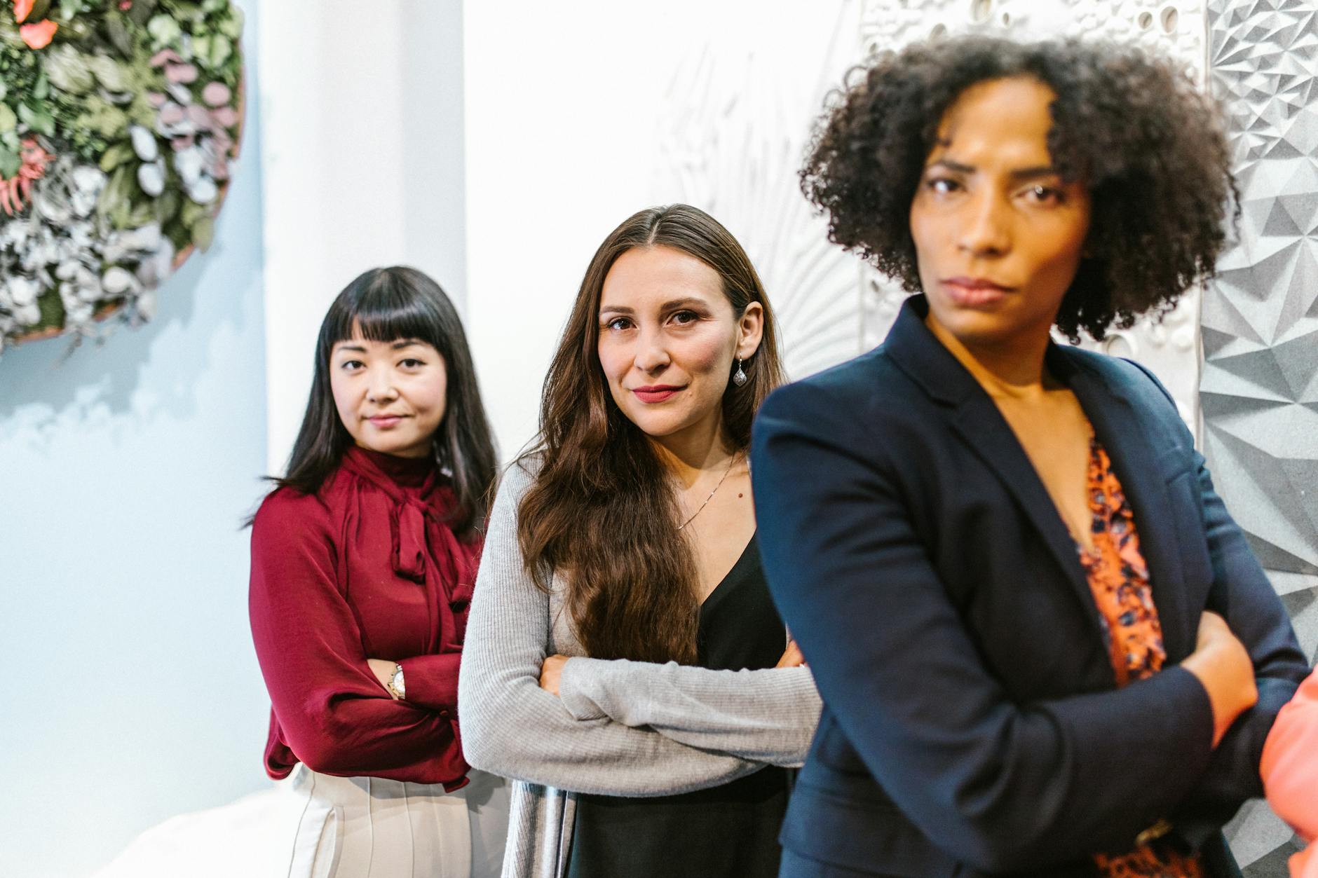 a group of women in business attire with their arms crossed