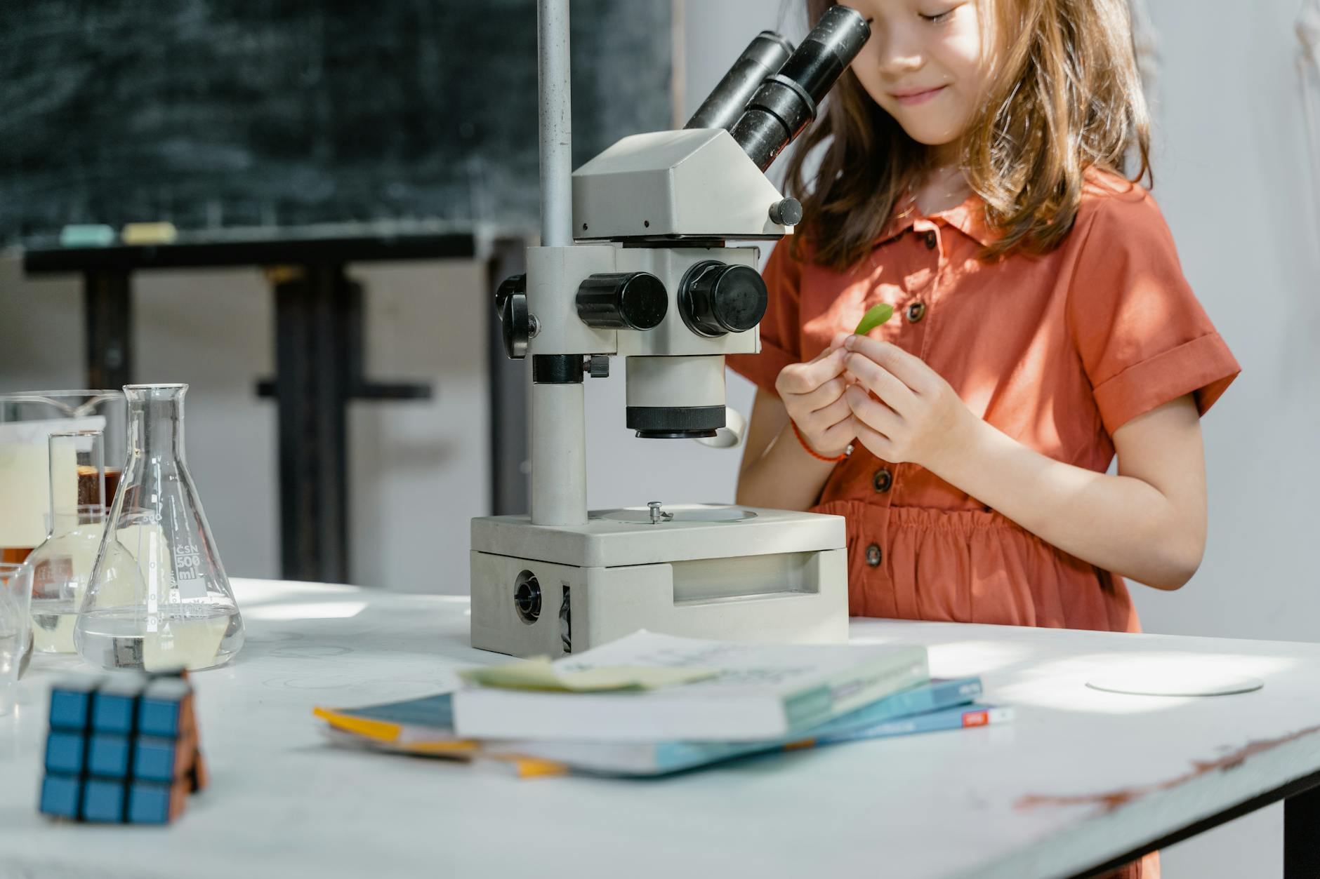 a smart girl standing by the microscope