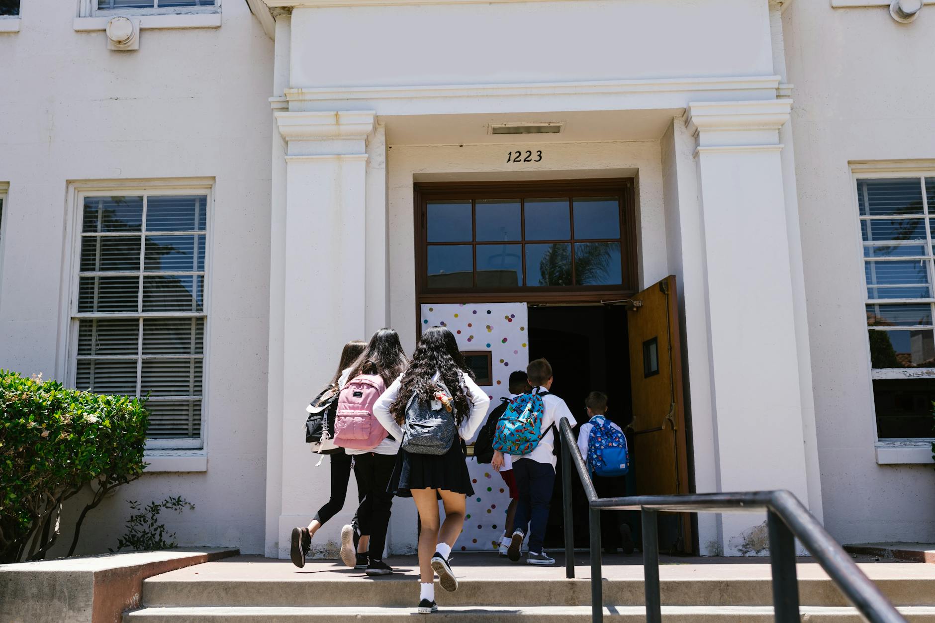 back view shot of students going inside the school