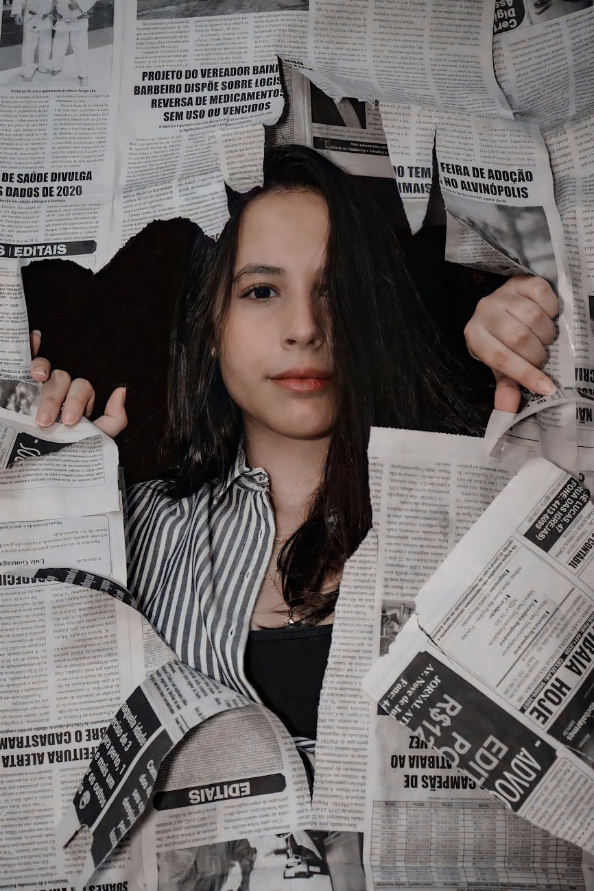 woman between torn newspaper