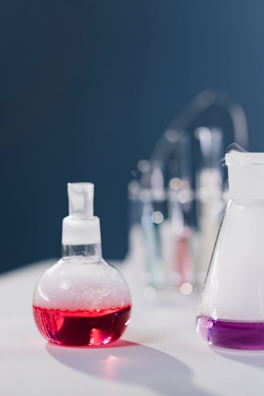 a close up shot of chemistry flasks with chemistry reaction