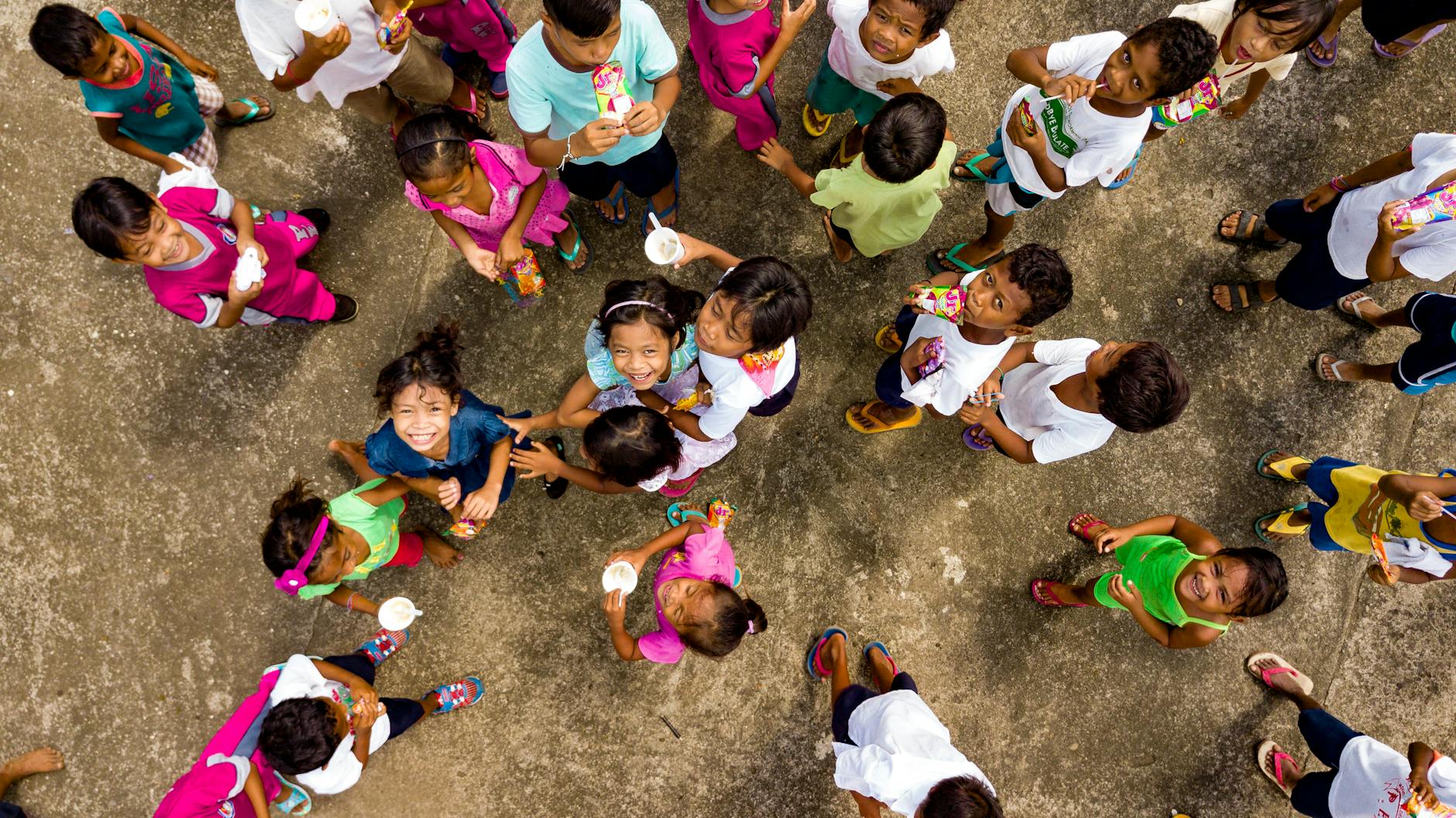 top view of smiling children on a concrete pavement