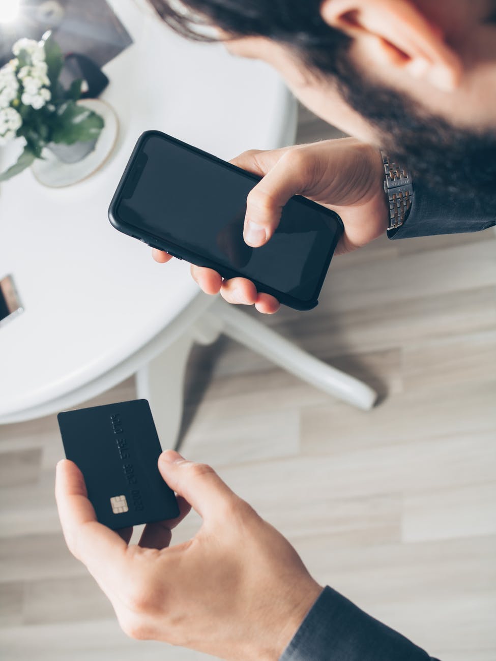 person holding a smartphone and a credit card