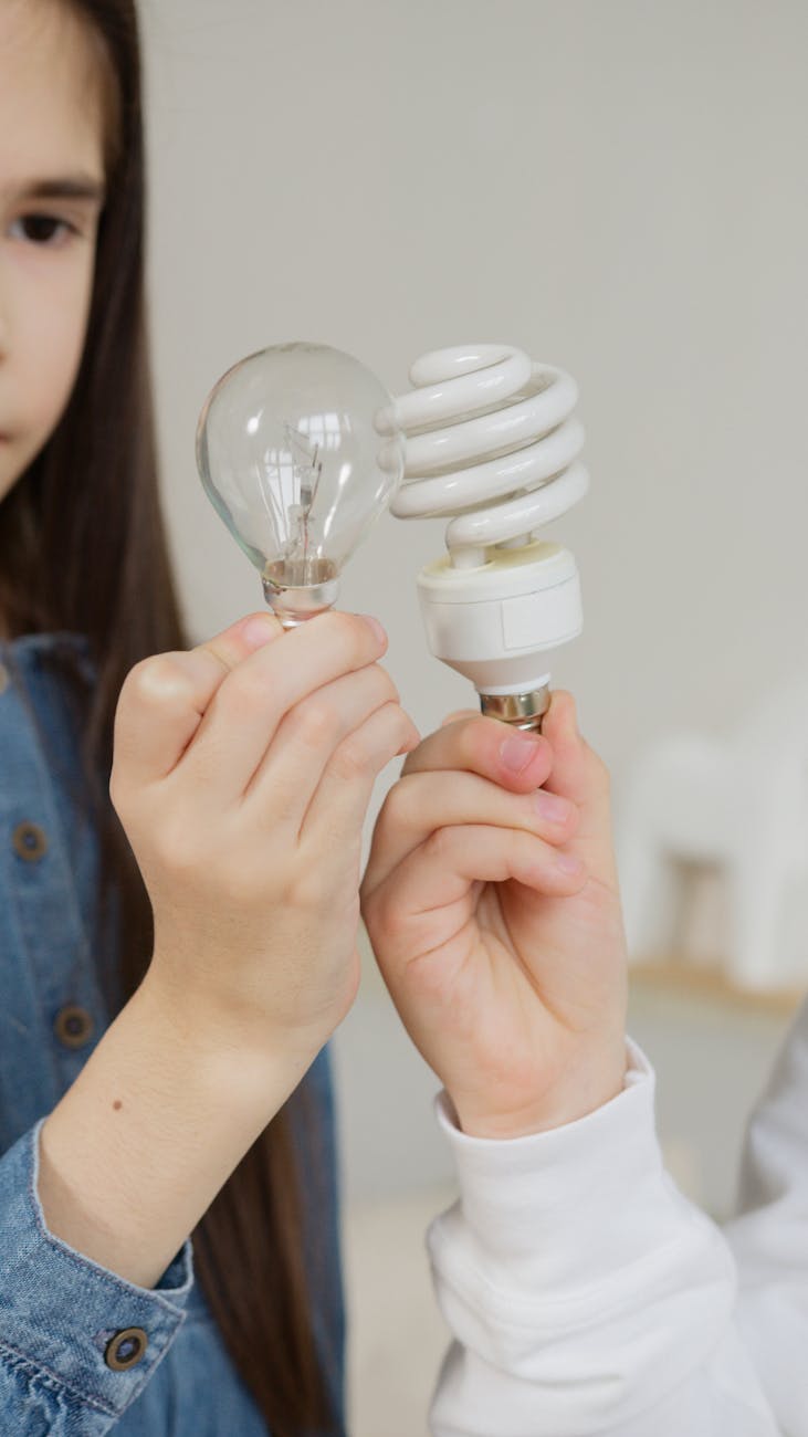 girl looking at two light bulbs