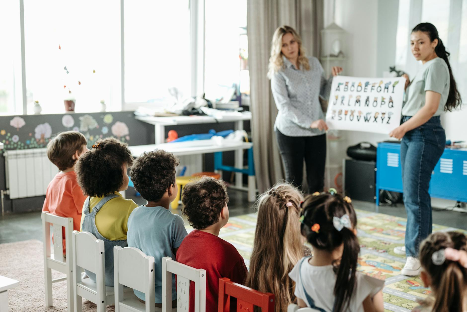 children sitting on stools in kindergarten