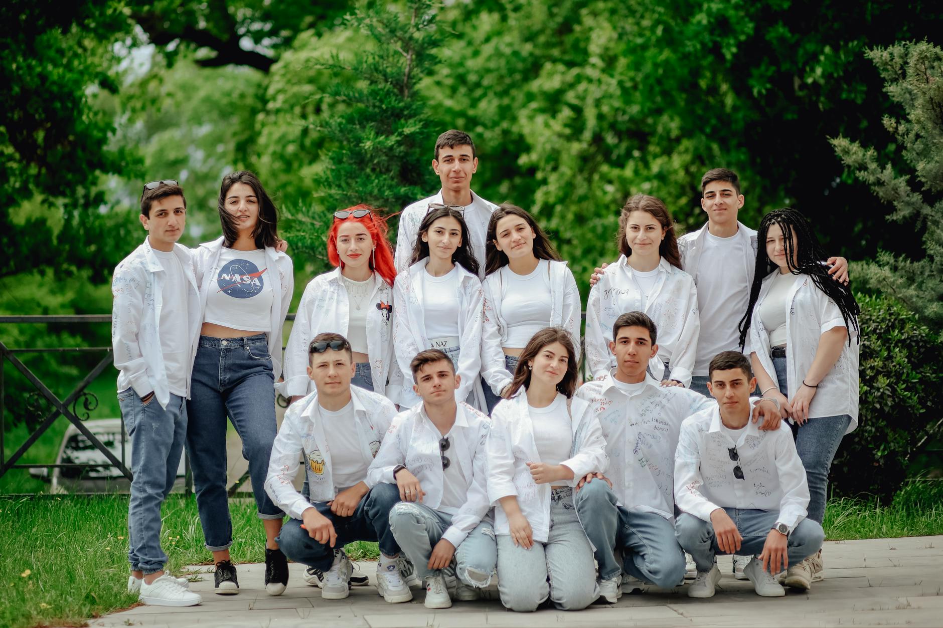 a group portrait of young people posing in white shirts
