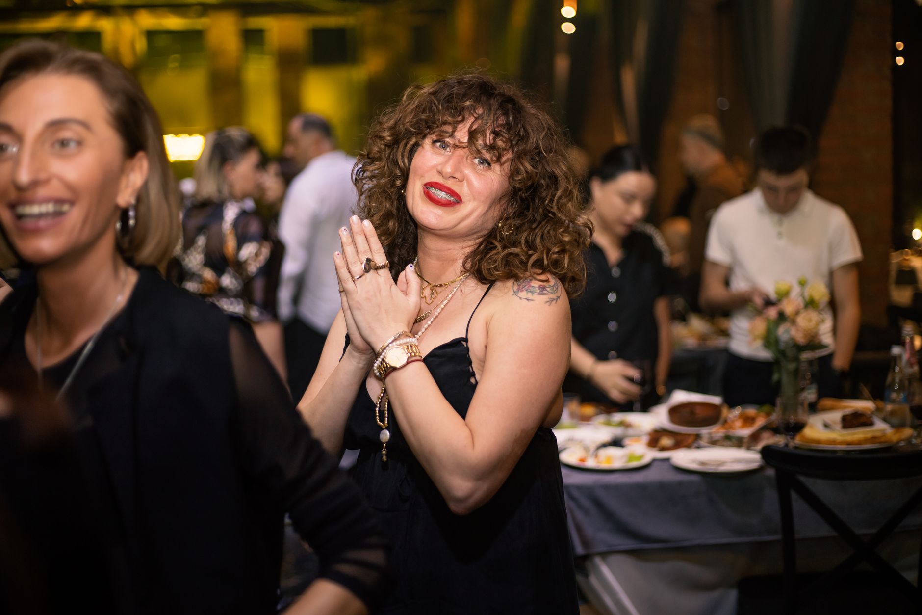 smiling woman with folded hands at a party