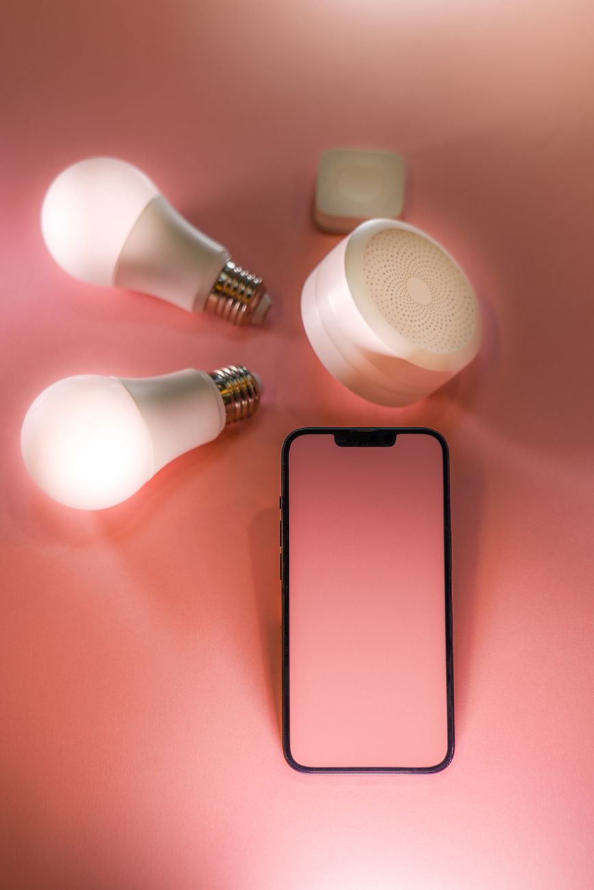 pink smartphone touchscreen and light bulbs around