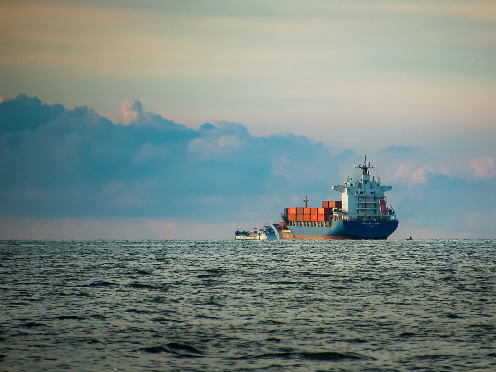 container ship sailing on open sea at dusk