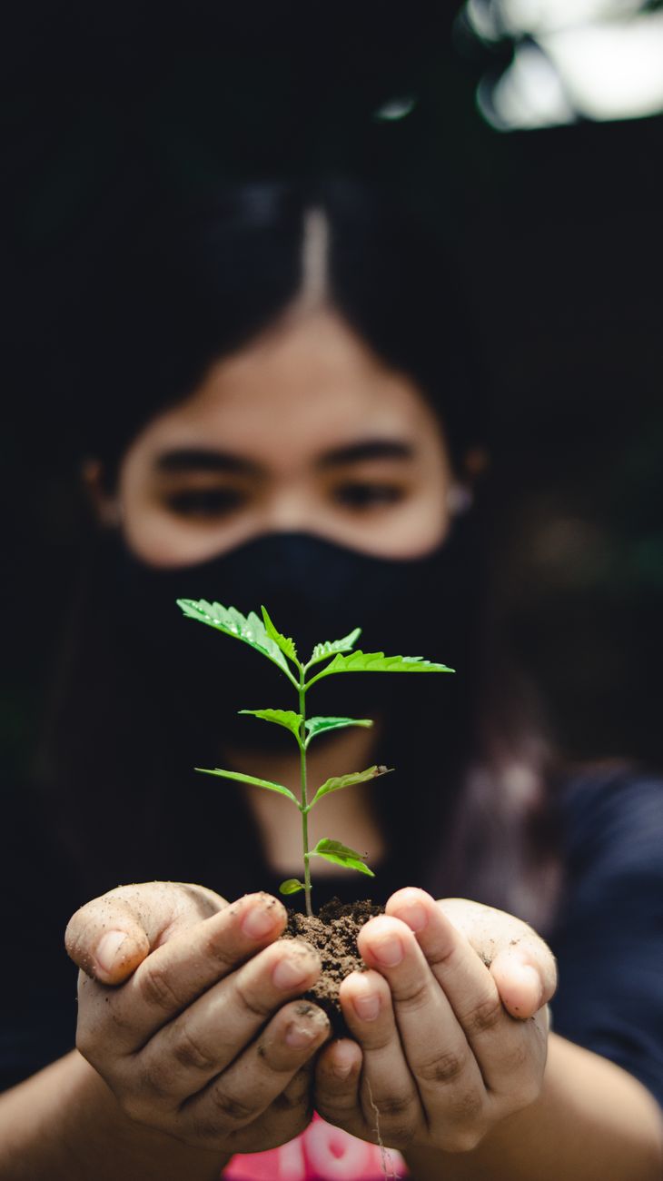 close up shot of a woman holding a plant