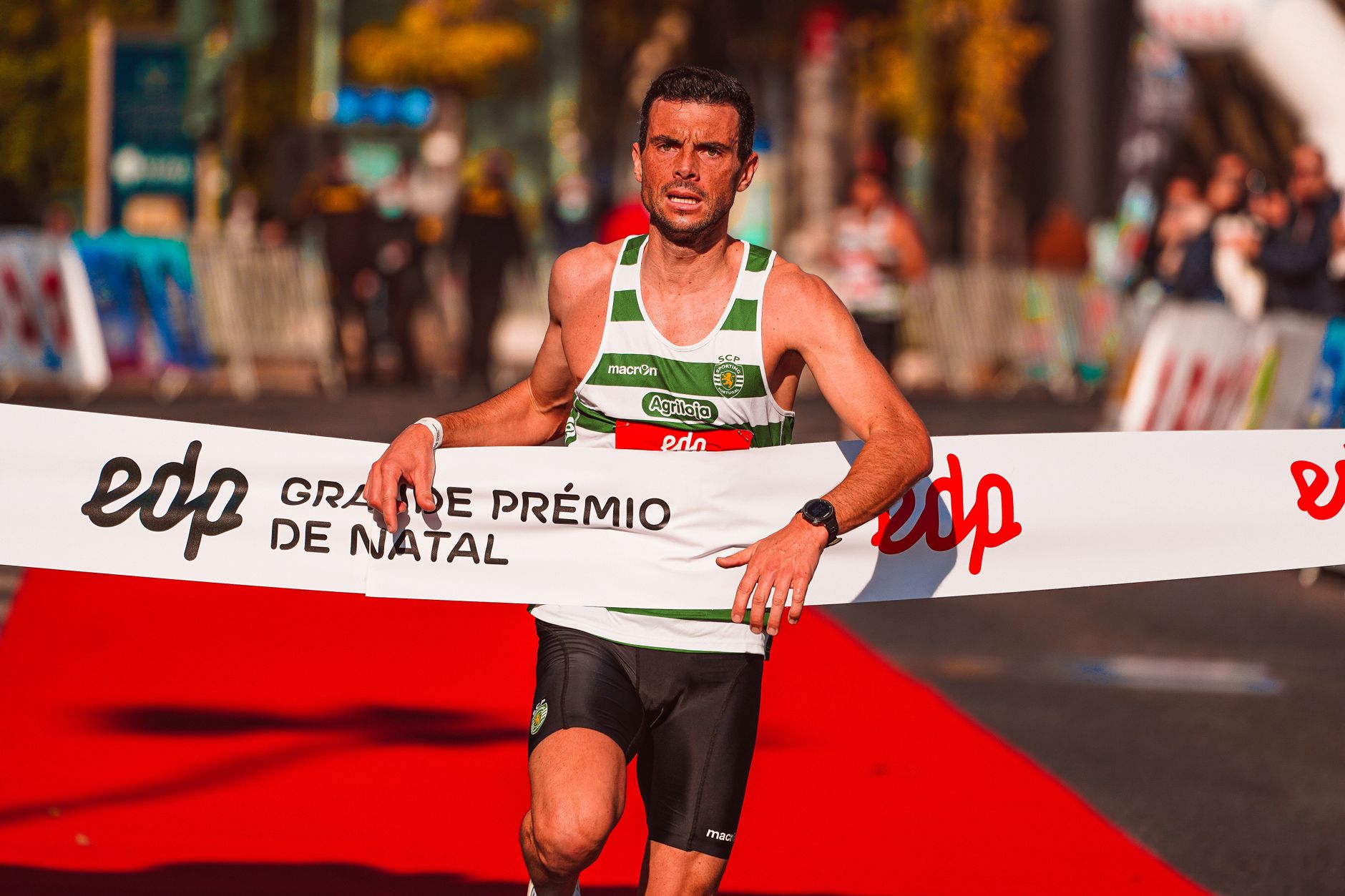 Athlete triumphantly crossing the finish line of the Grande Prémio de Natal race.