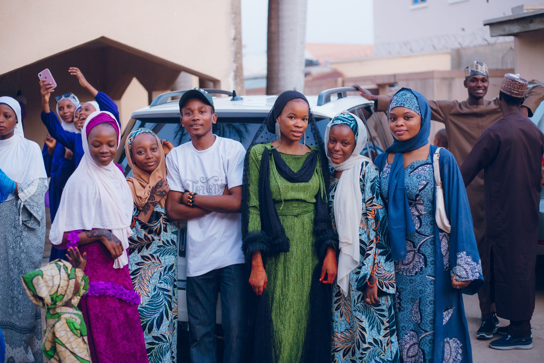 A vibrant outdoor gathering of adults in colorful traditional attire, capturing cultural expressions.