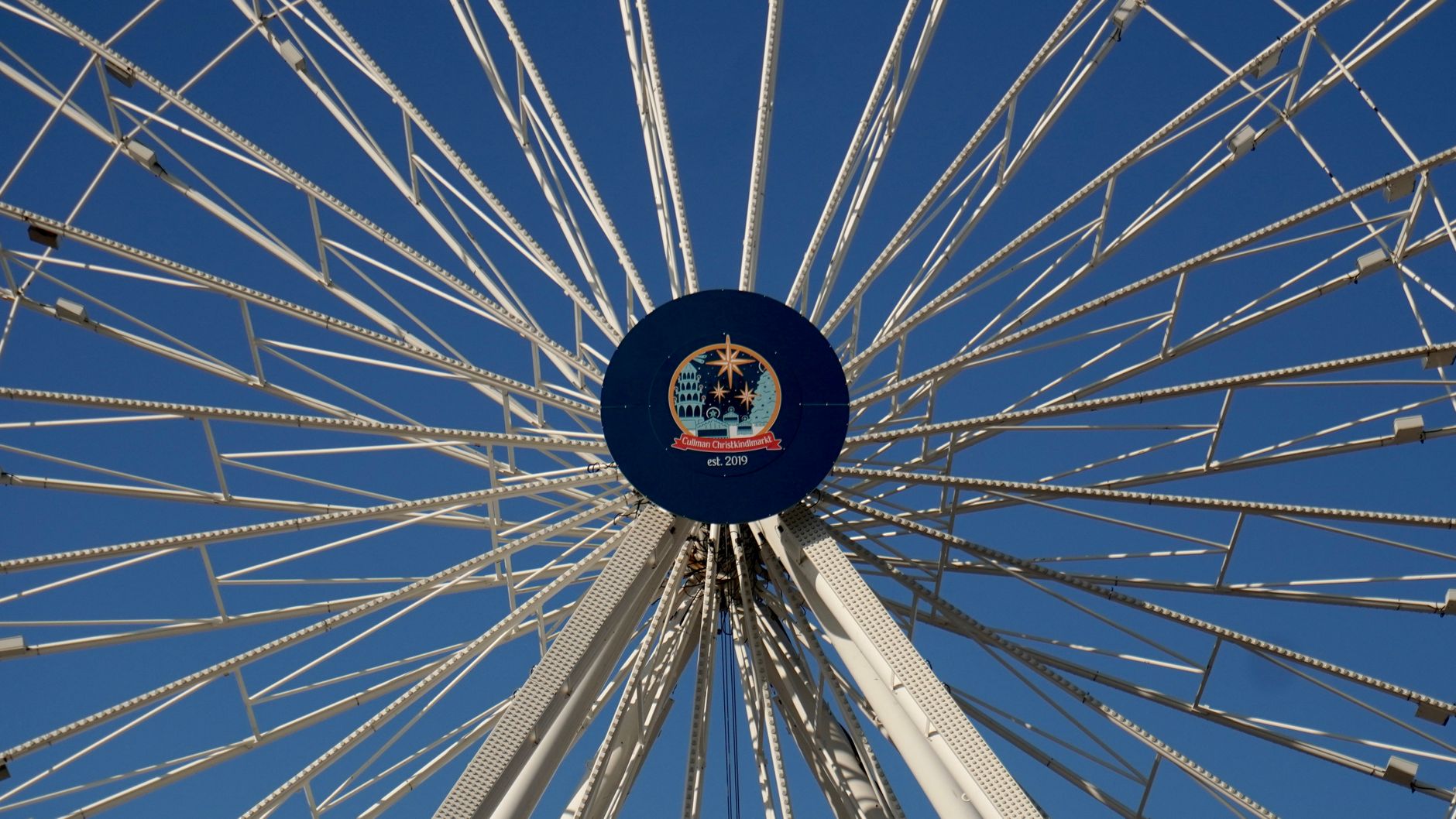 Close-up view of a Ferris wheel in Cullman, Alabama under a vibrant blue sky.