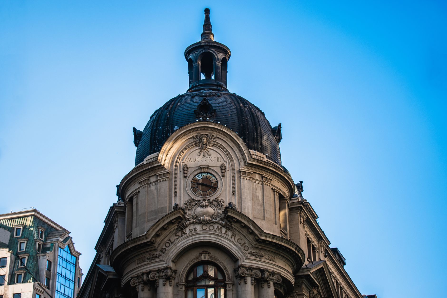 Low angle view of the iconic dome of the Santiago Stock Exchange building against a clear blue sky.