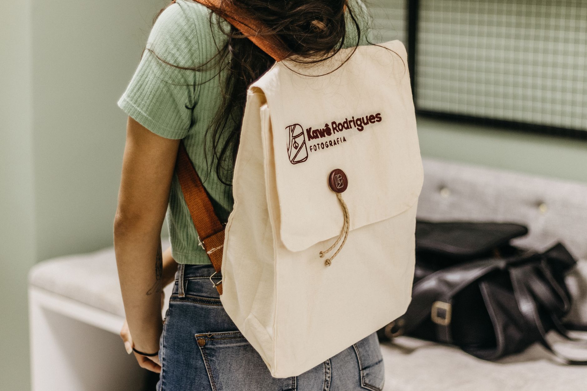 Woman with a beige backpack in a casual setting, showcasing everyday fashion style.