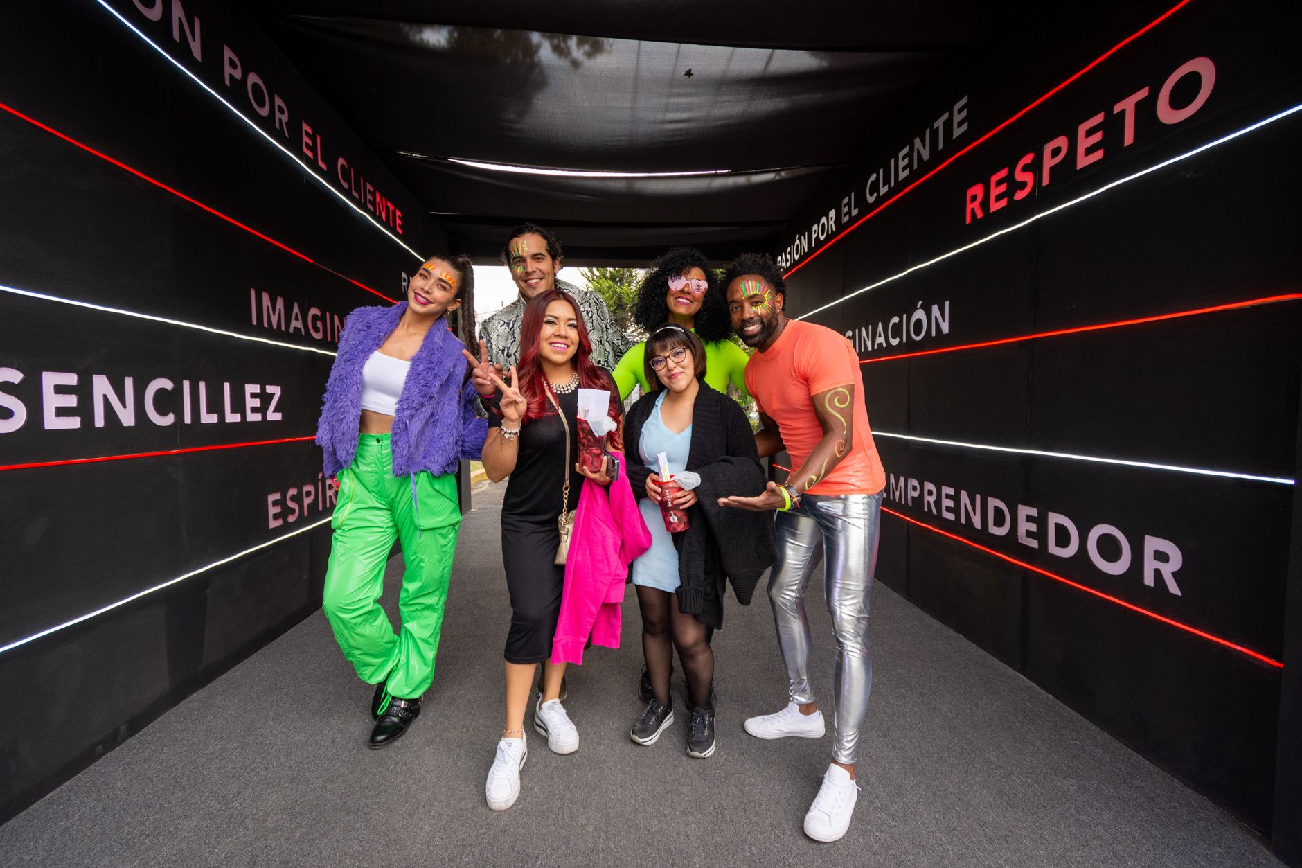A joyful group celebrating in a colorful, festive tunnel in Mexico City.