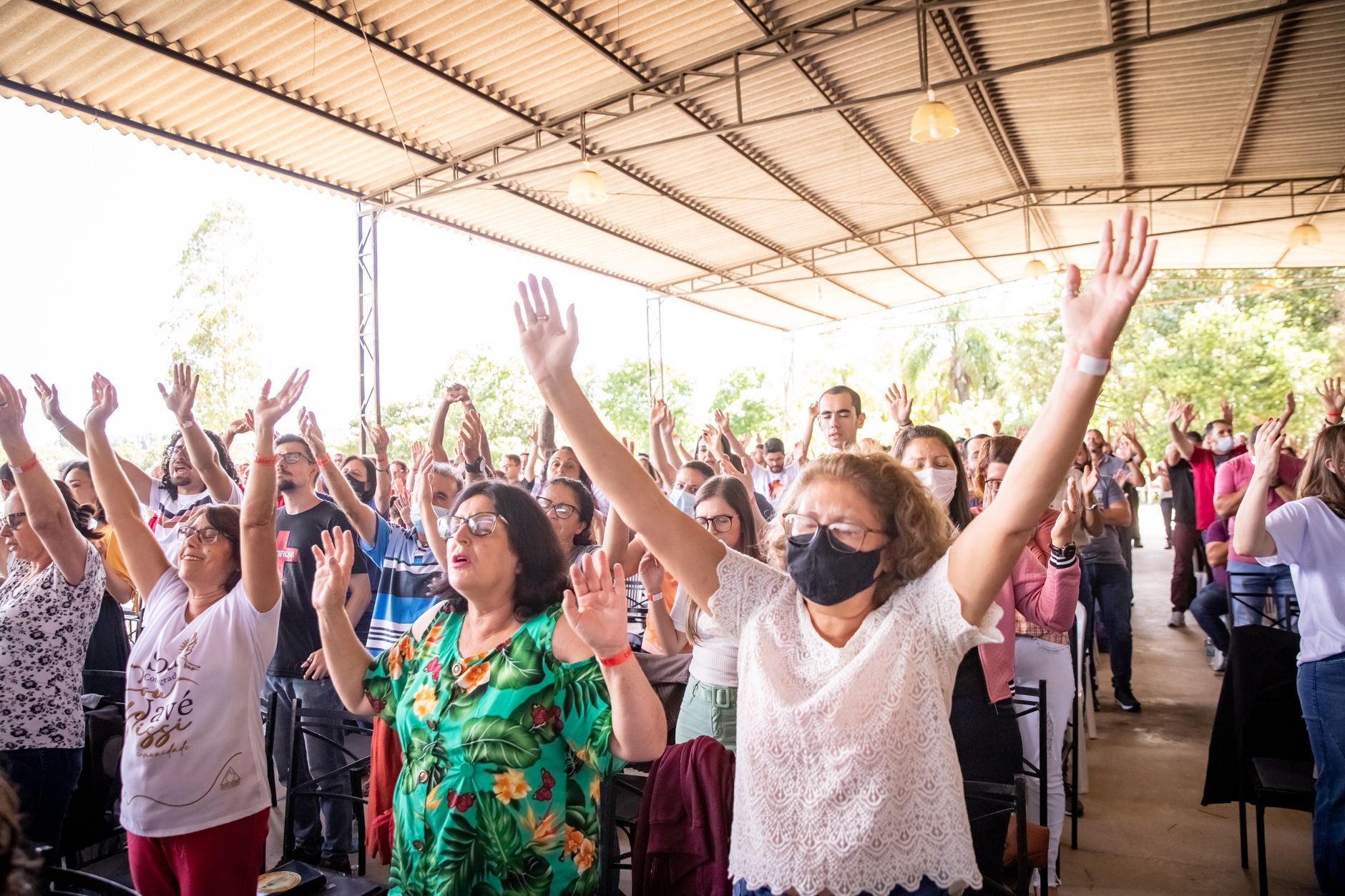 People with raised arms celebrate at a lively outdoor event filled with joy and energy.