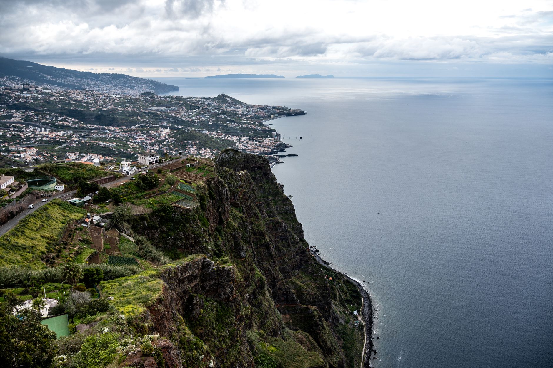 Stunning aerial shot of Câmara de Lobos, Madeira, showcasing cliffs and the Atlantic Ocean.