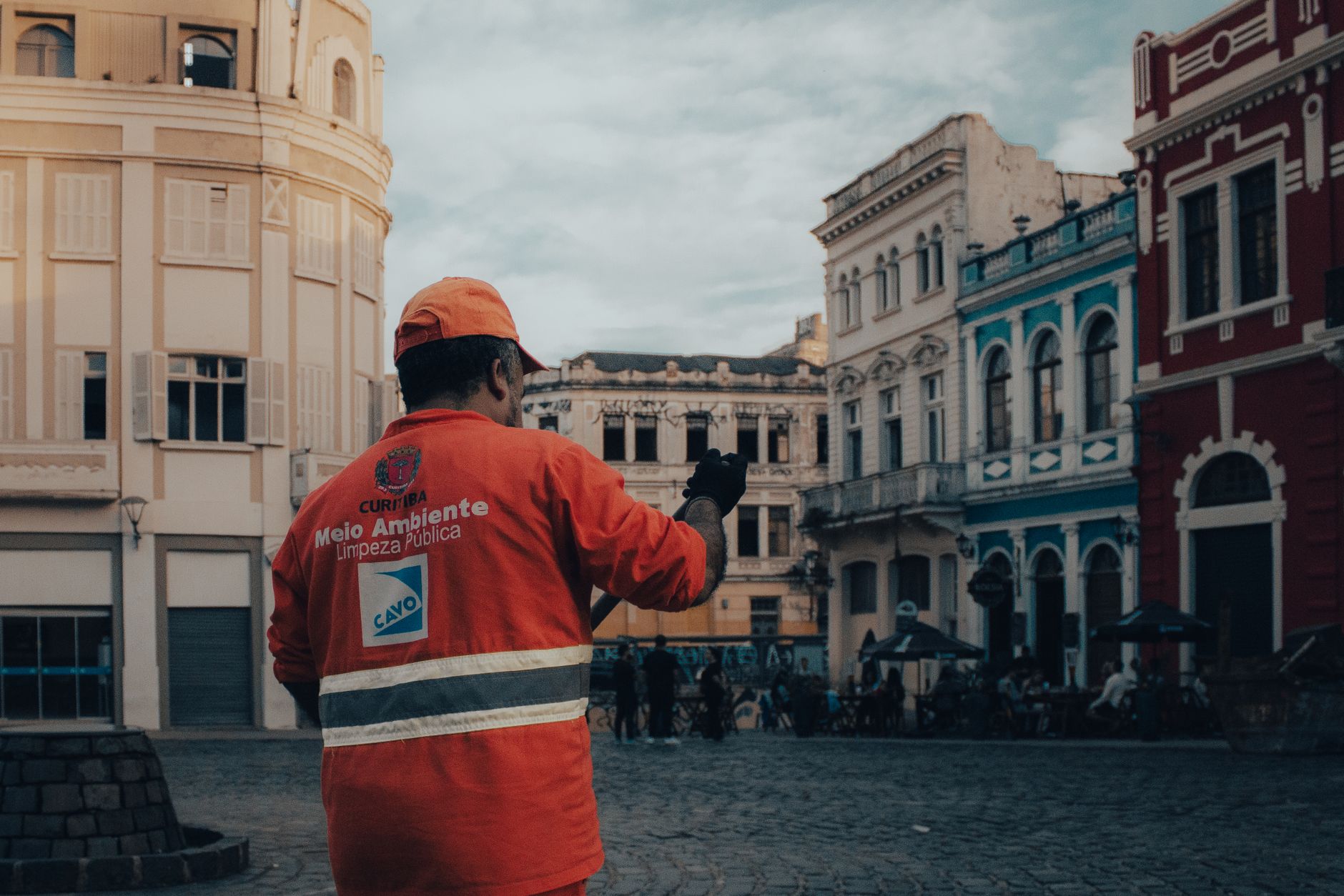 A city worker in a high visibility jacket walks through scenic old town Curitiba, Brazil.