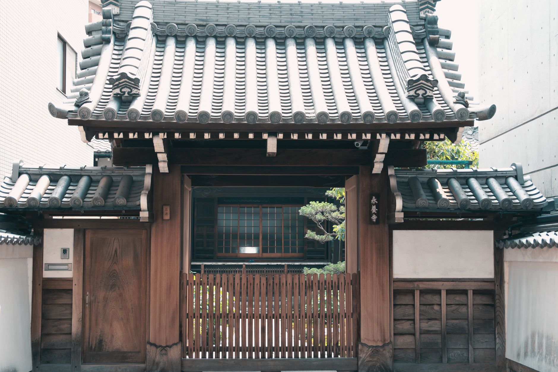 Wooden gate with traditional tiled roof in historic Kyoto, Japan.