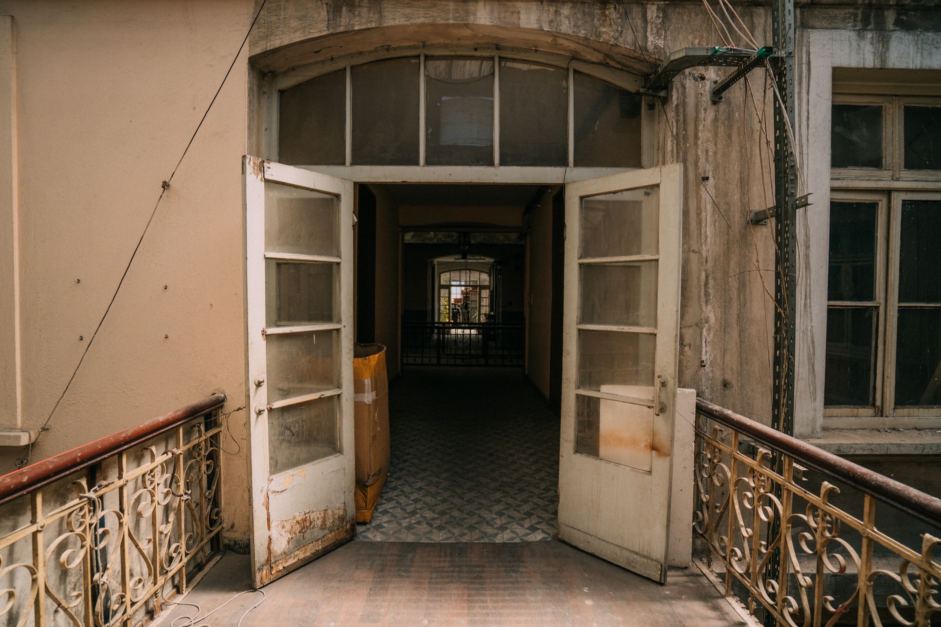 Vintage building exterior with open doors leading to a nostalgic hallway.