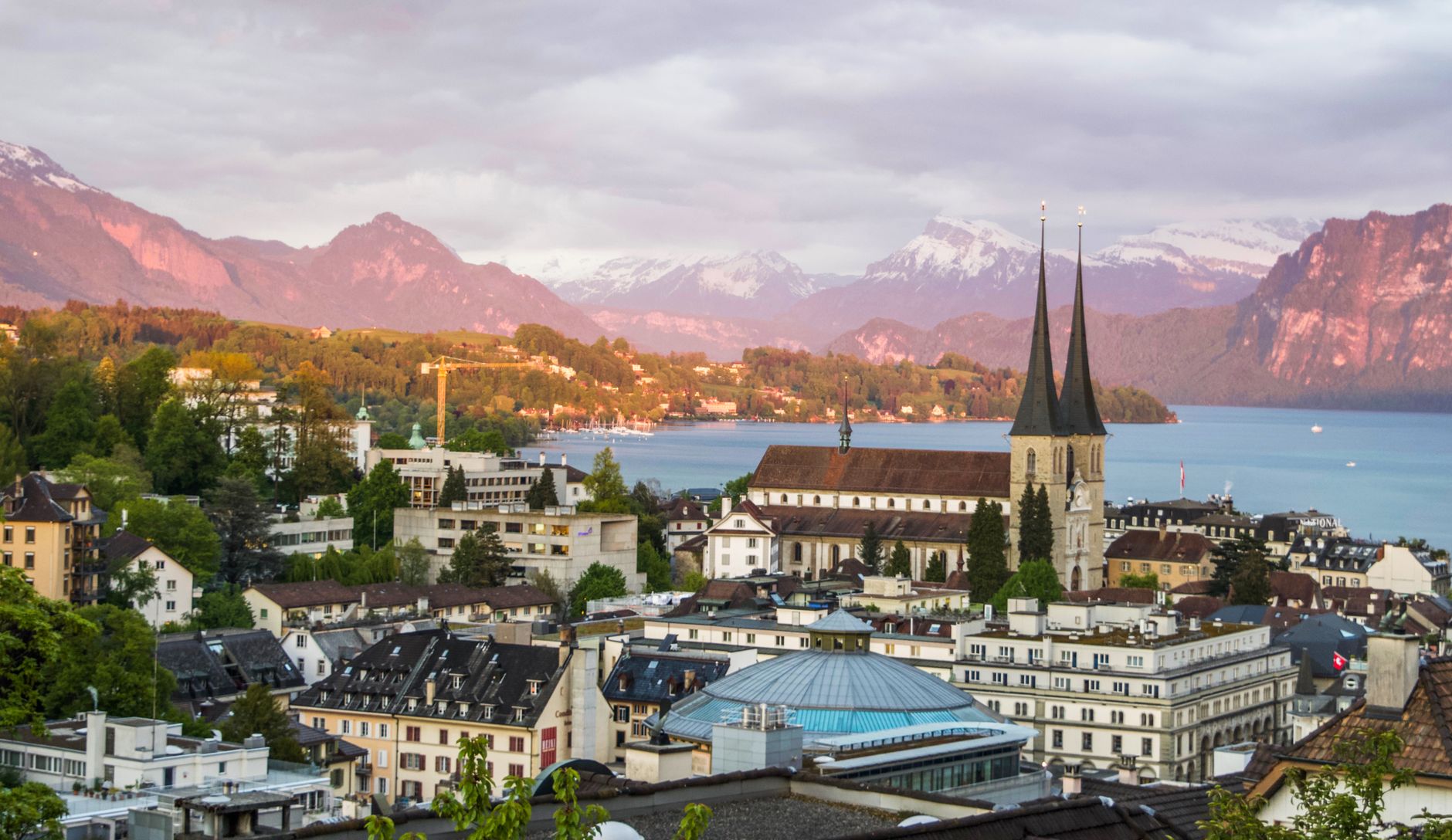 Majestic scenery of medieval city with Gothic cathedral in Alps on green seashore