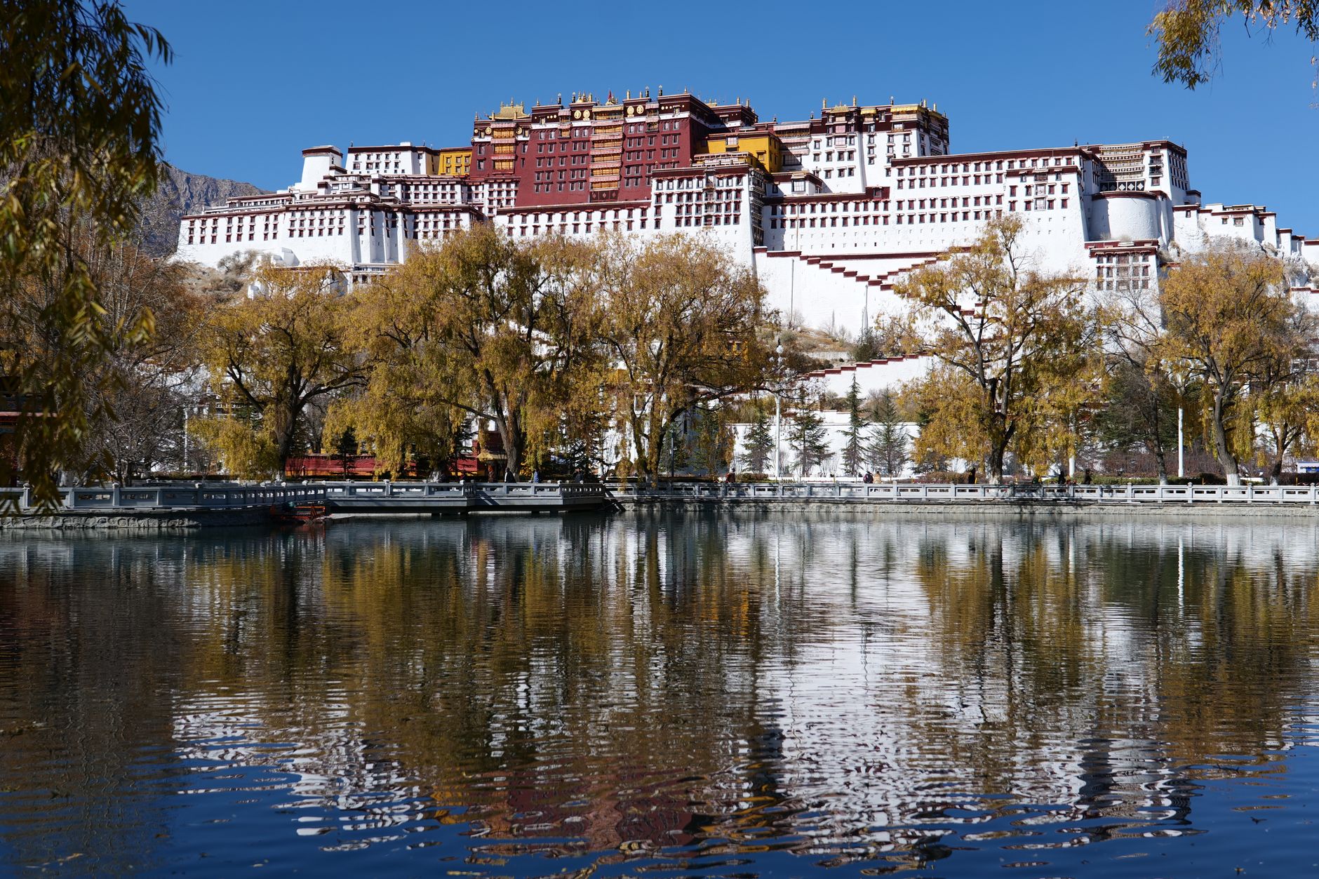 Stunning view of Potala Palace with its reflection in serene water in Lhasa, Tibet.